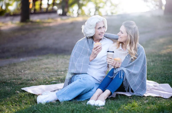 Mulher gostando de sobremesa com a mãe no parque — Fotografia de Stock