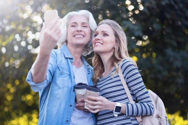 Elegante anciana tomando selfie con hija embarazada al aire libre —  Fotos de Stock