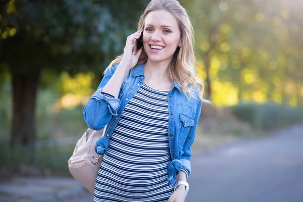 Χαρά έγκυος γυναίκα απολαμβάνοντας συνομιλία στο τηλέφωνο σε εξωτερικούς χώρους — Φωτογραφία Αρχείου