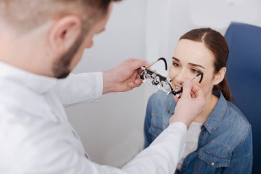 Güzel ciddi Doktor hastasına göz muayene gözlük koyarak