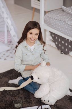 Mutlu çocuk yatak odasında kabarık ayı sarmak