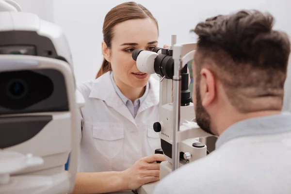 Belo oftalmologista agradável examinando a visão — Fotografia de Stock