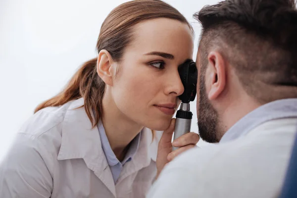 Angenehme hübsche Frau mit einem Ophthalmoskop — Stockfoto