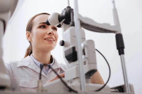 Alegre experiente oftalmologista usando equipamentos médicos — Fotografia de Stock