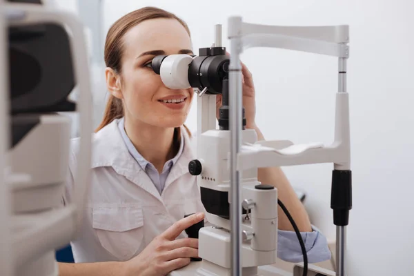 Trevlig kvinnlig ögonläkare med fokus på hennes arbete — Stockfoto