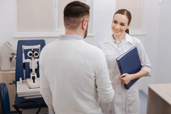 Freudig glücklicher Arzt hält einen Ordner in der Hand — Stockfoto