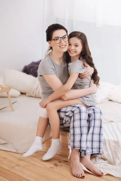 Gelukkig moeder en dochter thuis knuffelen — Stockfoto