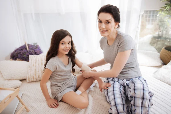 Vrolijke jonge moeder en dochter genietend van geneeskunde thuis — Stockfoto