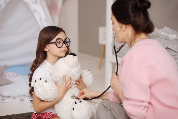 Paciente niño tratando peluche con madre en casa —  Fotos de Stock