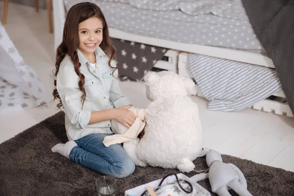 Encantadora chica vendaje juguete en casa —  Fotos de Stock
