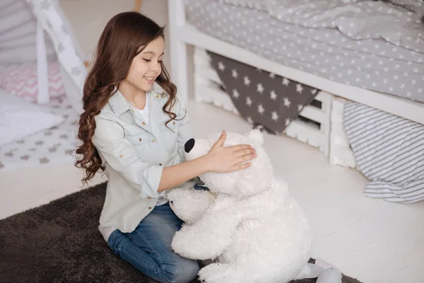 Niño animado abrazando oso esponjoso en el dormitorio —  Fotos de Stock