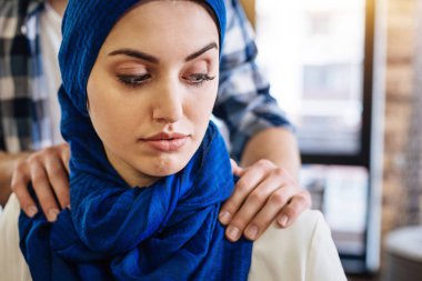 Muslim woman beign herrased by representative of another group clipart