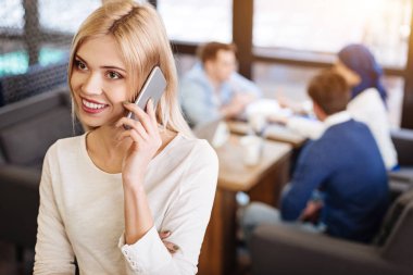 Gülümseyen güzel kadın telefonu kafede söz
