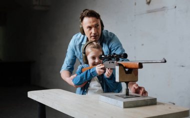 Güzel sevimli kız bir silah kullanmayı öğrenme