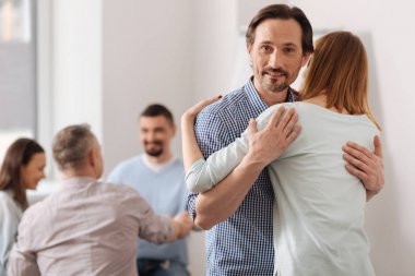 Doğruca kameraya bakarak gülen esmer