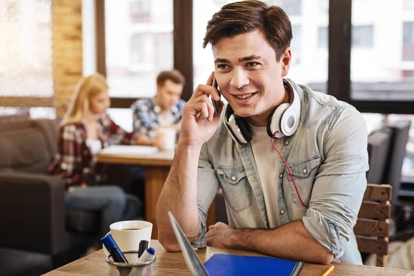 Vrolijke jonge man zitten in het cafe — Stockfoto