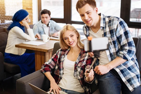 Usmívající se studenti sedí v kavárně — Stock fotografie