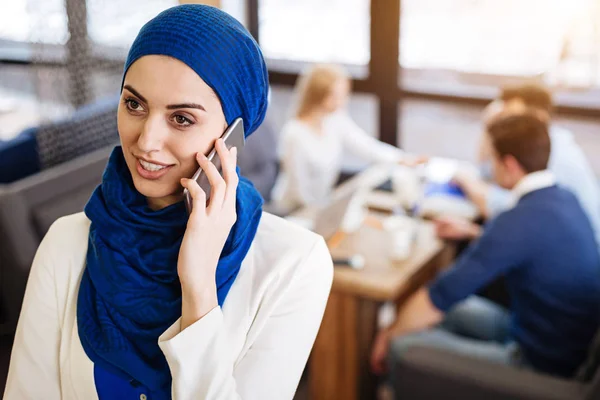 Mulher muçulmana agradável falando no telefone inteligente — Fotografia de Stock