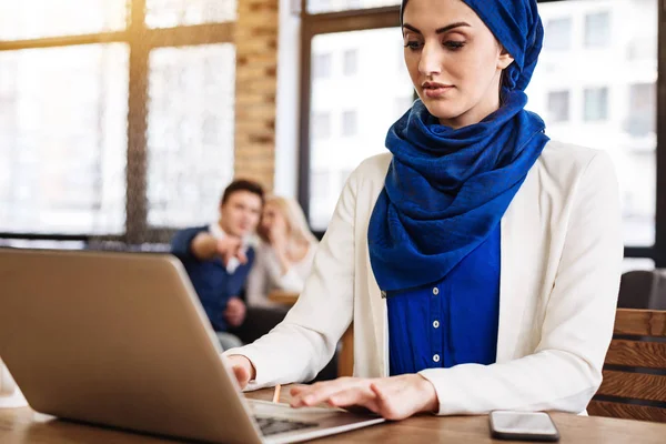 Příjemné muslimské podnikatelka pracující na přenosném počítači — Stock fotografie