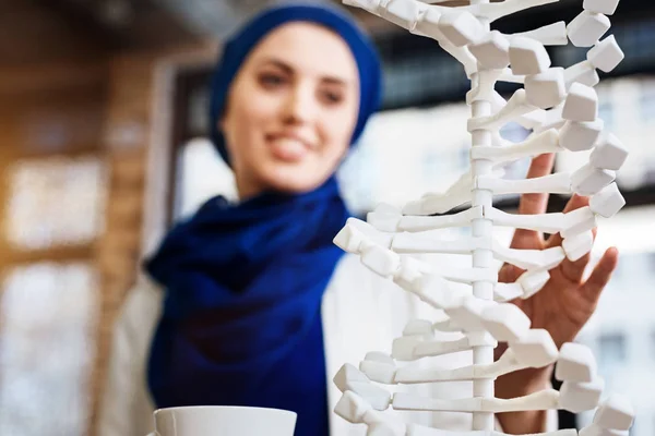 Foco seletivo do modelo de DNA nas mãos do estudante muçulmano — Fotografia de Stock