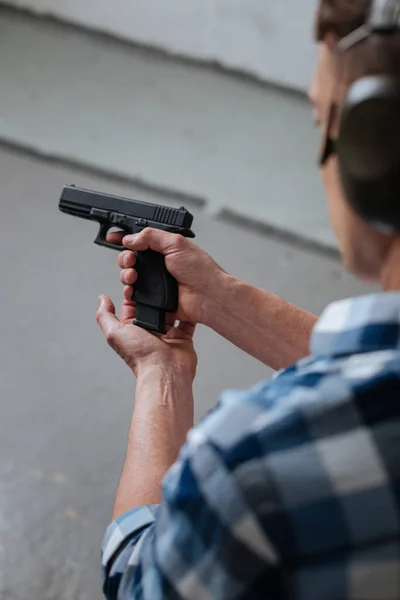 Brutal professional marksman reloading his gun — Stock Photo, Image
