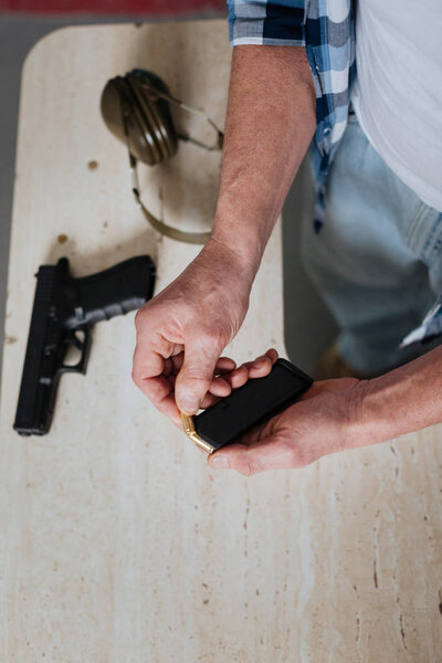 Красивый жестокий человек, держащий патрон
