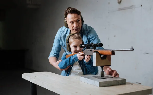 Leuk schattig meisje leren gebruiken van een pistool — Stockfoto