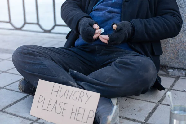 Närbild av hemlös person att hålla pengar i höger hand — Stockfoto