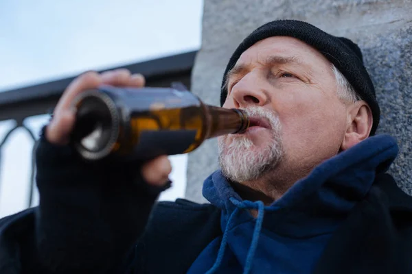 Retrato de homem triste mantendo garrafa de vidro perto da boca — Fotografia de Stock