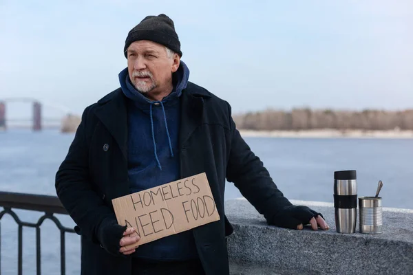 Бездомный пенсионер стоит у колонны — стоковое фото