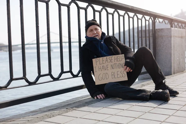 Poor male person holding cardboard in left hand — Stock Photo, Image