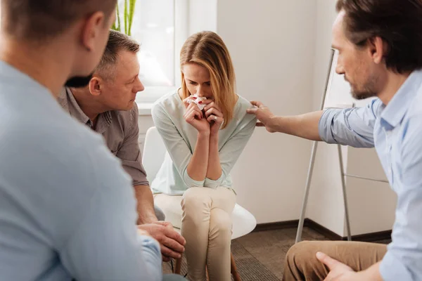 Enttäuschte Frau legt ihre Ellbogen auf das linke Bein — Stockfoto