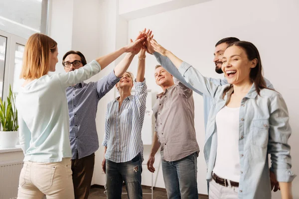 Positive delighted team rising hands — Stock Photo, Image