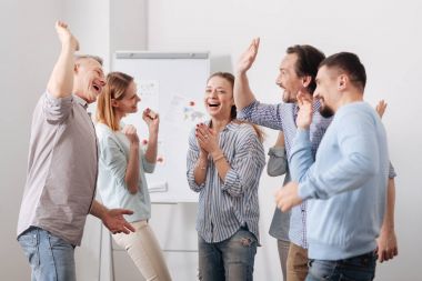 İş arkadaşları arasında duran mutlu kadın