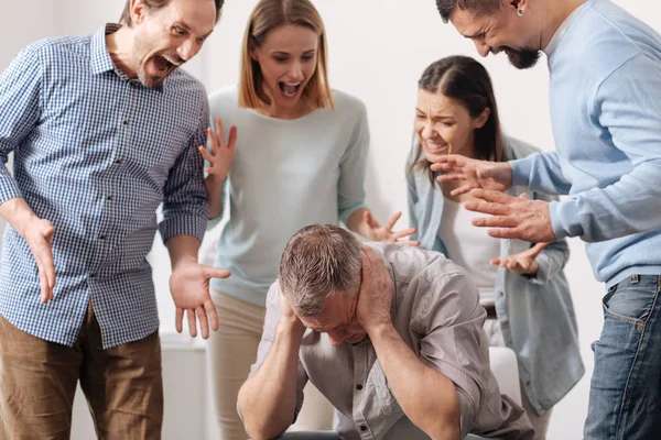 Jovens colegas gritando com seu colega de trabalho — Fotografia de Stock