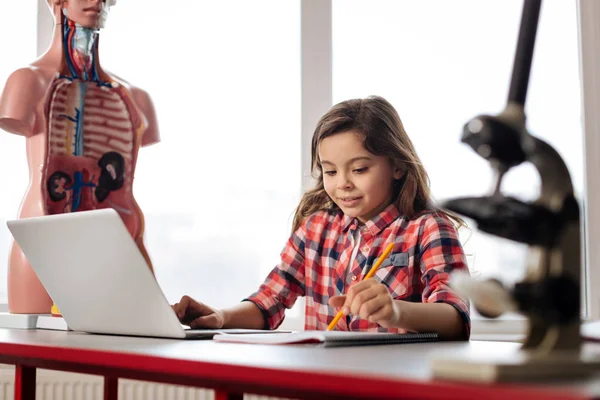 Étude fille sur la biologie tout en utilisant un ordinateur portable — Photo