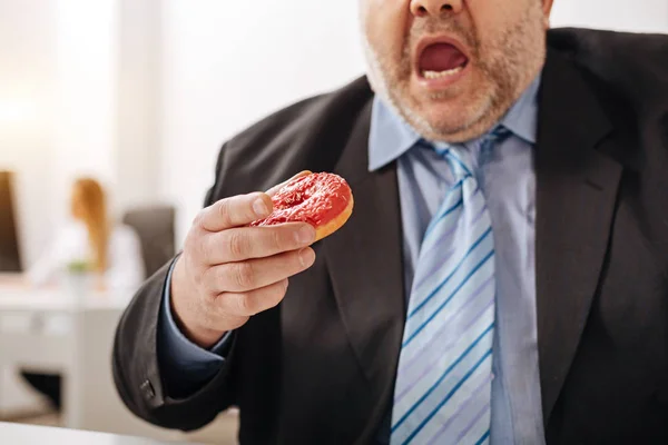 Funny compulsive guy eating a doughnut — Stock Photo, Image