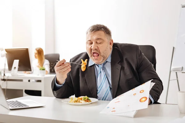 Overloaded busy businessman having lunch at work — Stock Photo, Image