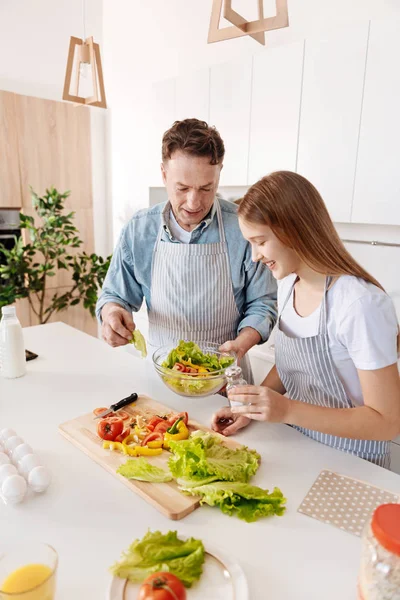 Vista superior de la ensalada de cocina alegre padre e hija — Foto de Stock