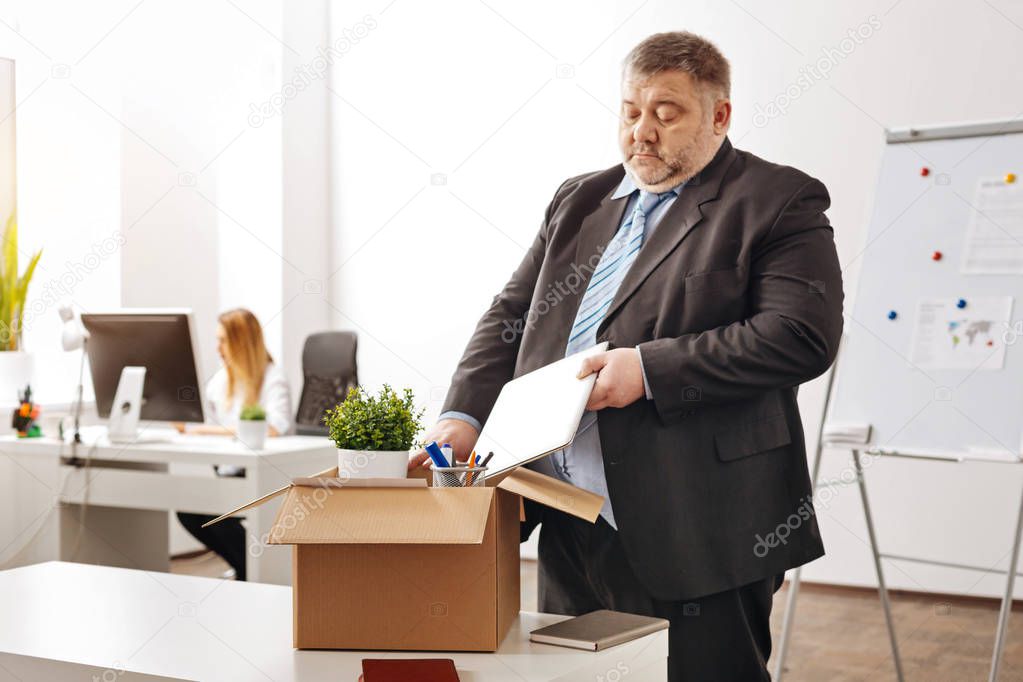Disappointed ambitious employee leaving his workplace