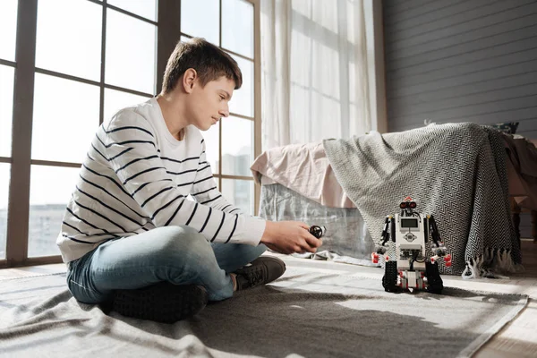 Glada unga manliga person som spelar med robot — Stockfoto