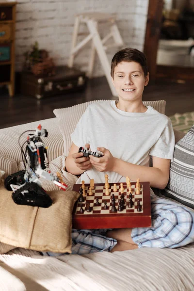 Garoto encantado jogando xadrez com seu robô — Fotografia de Stock