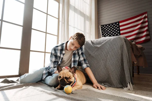 Potěšen teenagera, sedí poblíž jeho nejlepší psí kamarád — Stock fotografie
