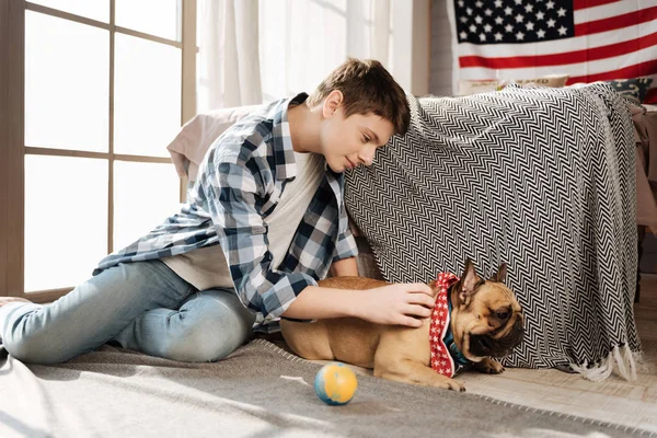 Ragazzo sorridente seduto in posizione semi con il suo animale domestico — Foto Stock