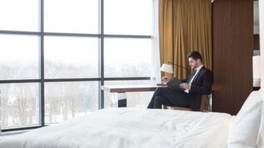 Otel odasında otururken ciddi iş adamı