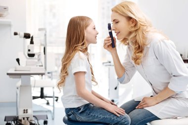 Kızlar gözleri gözlemleyerek ophthalmoscope ile göz doktoru