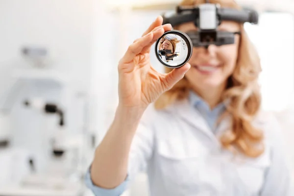 Профессиональная женщина-врач, использующая непрямой офтальмоскоп — стоковое фото
