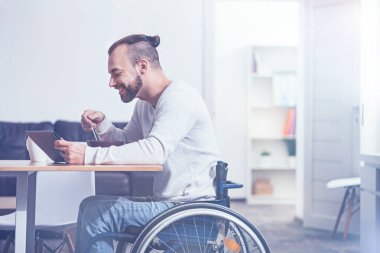adam tekerlekli sandalye üzerinde oturan ve kahvaltı keyfi
