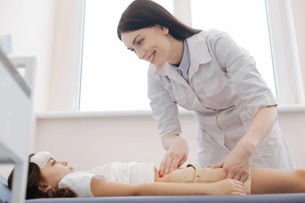 Positieve vrouw arts kijken meisje — Stockfoto