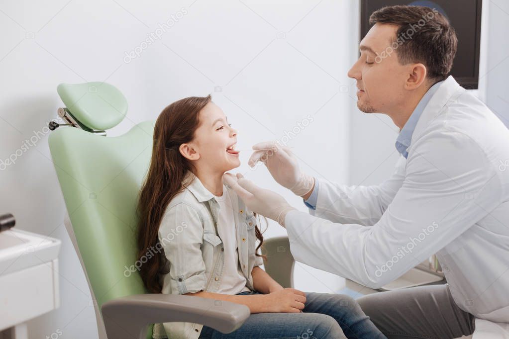 otolaryngologist checking throat of his patient